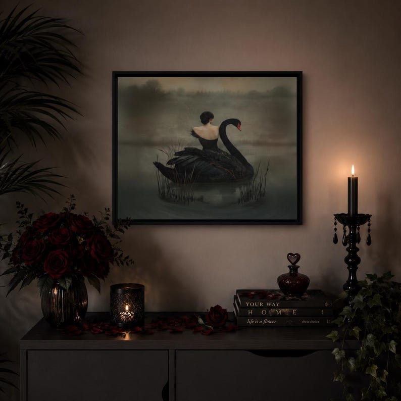 May include: A framed artwork depicts a woman on a black swan in a lake. The scene is dark and moody, with a black candle and a bouquet of red roses on a dark cabinet. A small, heart-shaped bottle and books are also on the cabinet.