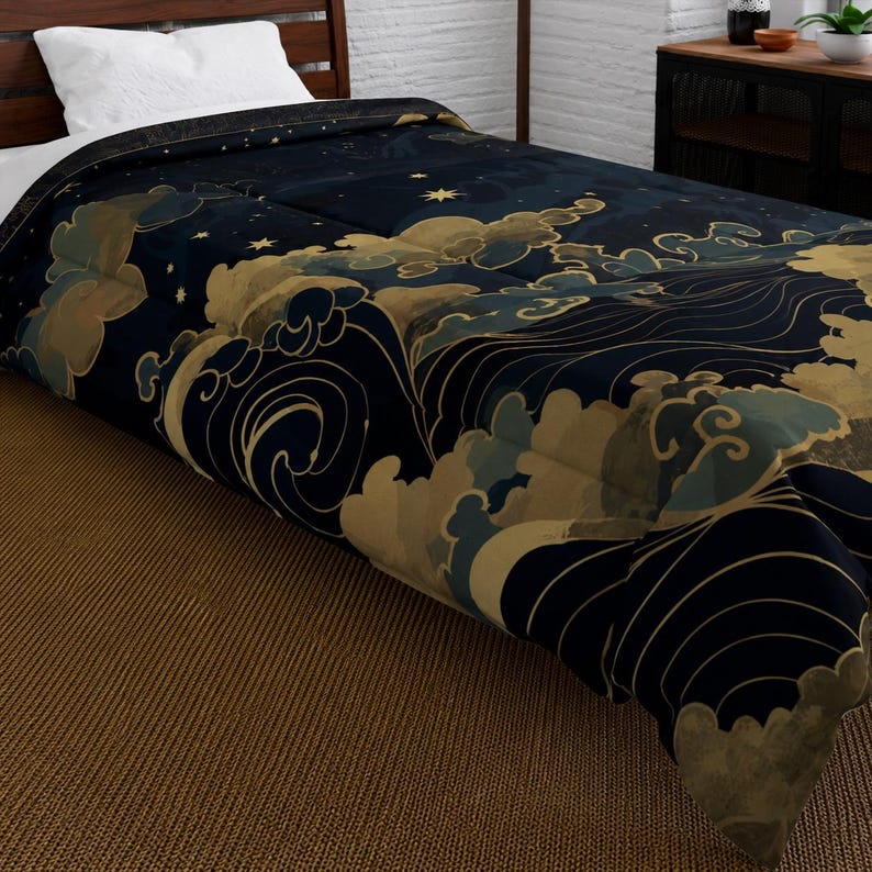 May include: A navy blue comforter with a gold and light blue wave and cloud design. The bedding features a starry night sky pattern and is placed on a bed with a white pillow.