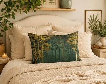 May include: A decorative rectangular pillow with a forest scene in shades of green and gold. The pillow is on a bed with other pillows and a cream-colored blanket. The bed is in a well-lit room with plants and artwork.