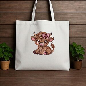 May include: White tote bag with an embroidered cartoon Highland cow wearing a pink bow. The cow is brown with pink details. The bag has white handles and is made of a durable fabric. Ideal for carrying books, groceries, or everyday items.