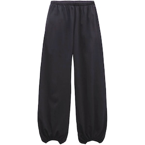 Pu&ograve; includere: Pantaloni neri a tinta unita caratterizzati da una silhouette ampia e rilassata, con vita elasticizzata e polsini arricciati con elastico alle caviglie. Il capo &egrave; realizzato in un tessuto liscio e opaco di un colore scuro uniforme.