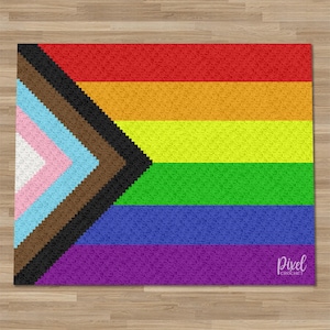 May include: A handmade crochet rug featuring the Progress Pride flag design. The rug displays the traditional rainbow stripes, along with the chevron of colors representing the transgender community, people of color, and those living with or lost to AIDS. The text "Pixel Crochet" is in the bottom right corner.