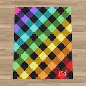Op de afbeelding: Een rechthoekige gehaakte deken met een diagonaal ruitpatroon van afwisselende zwarte vierkanten en een regenboogkleurverloop inclusief roze, paars, blauw, groen, geel, oranje en rood. De tekst Pixel Crochet is in het wit afgedrukt.