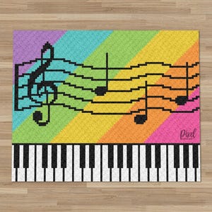 Può includere: Un tappeto rettangolare con un vivace sfondo arcobaleno diagonale, un pentagramma musicale, una chiave di violino e note musicali pixelate in nero. La sezione inferiore mostra un motivo a tastiera di pianoforte in bianco e nero. La parola Pixel è stampata nell'angolo.