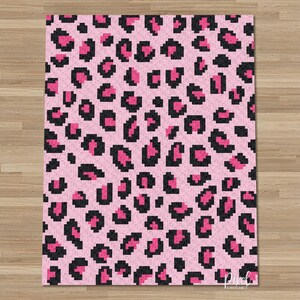 May include: A pink and black leopard print rug. The rug has a repeating pattern of black spots with pink centres on a pink background. The rug is rectangular and appears to be made of a soft material. The design is pixelated.