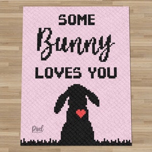 Puede incluir: Un diseño de arte de píxeles rosa con el texto "Some Bunny Loves You" y una silueta negra de un conejito con un corazón rojo en el pecho.