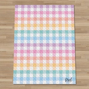 May include: A colorful, checkered pattern rug in pastel shades of pink, orange, yellow, blue, and purple. The rug has a gingham design, with the Pixel Crochet logo in the bottom right corner. The rug is rectangular and sits on a wooden floor.