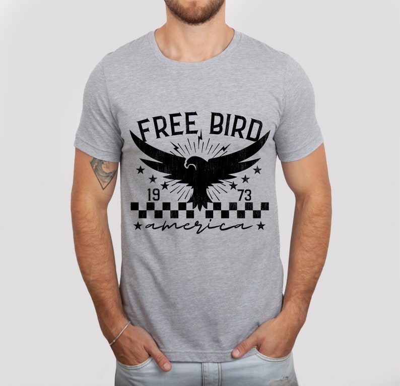 May include: A gray t-shirt with a black graphic of an eagle with the text "FREE BIRD" above it and "1973 america" below it.