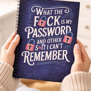 Pode incluir: Um caderno espiralado azul escuro com o texto "What the F*ck is my Password and other s*it I can't remember." O design inclui fontes decorativas, cadeados e um fundo estrelado.