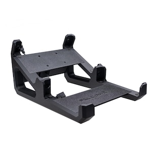 May include: Black metal laptop stand with a textured surface and the word "FALCON2" printed on the bottom. The stand has a raised platform for the laptop and a lower shelf for a keyboard or mouse.