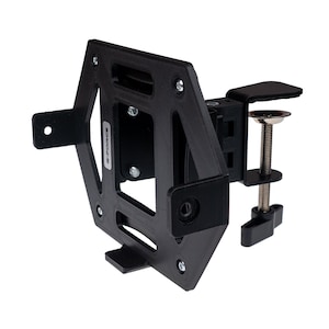 May include: Black metal clamp mount with a square plate for attaching a device. The clamp has a screw to tighten it to a surface.