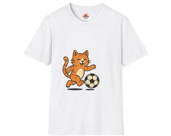Op de afbeelding: Wit t-shirt met een cartoon illustratie van een kat die voetbal speelt. De kat is oranje met bruine strepen en trapt tegen een zwart-witte voetbal. Het shirt heeft een klein logo bij de halslijn.