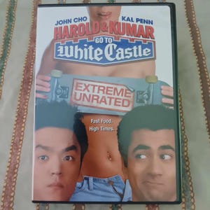 May include: DVD cover for the movie Harold & Kumar Go to White Castle. The cover features John Cho and Kal Penn, the stars of the movie, and the title of the movie in large, white letters. The tagline "Extreme Unrated" is also featured on the cover.
