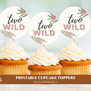 May include: Three cupcake toppers with a white background and pink and green floral accents. The toppers feature the text "two wild" in black and pink lettering. The toppers are designed for a two-year-old birthday party.