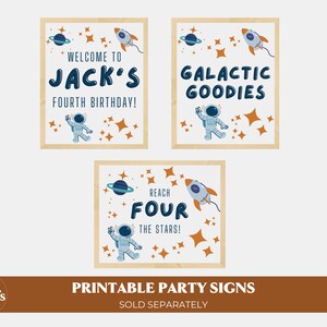 May include: Three printable party signs with a space theme. The signs feature an astronaut, a rocket ship, planets, and stars. The text on the signs reads "Welcome to Jack's Fourth Birthday!", "Galactic Goodies", and "Reach Four The Stars!"