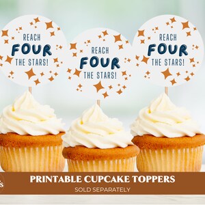 May include: Three white cupcakes with vanilla frosting topped with round, white cupcake toppers that say "Reach Four The Stars!" in navy blue and orange star accents.