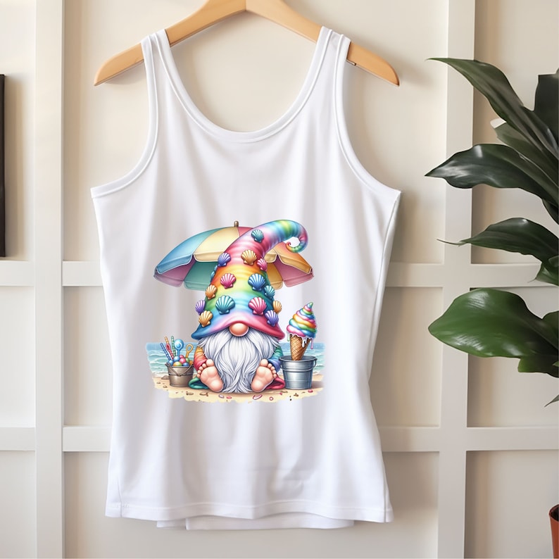 May include: White tank top featuring a colourful gnome wearing a rainbow hat with seashells, holding an ice cream cone and sitting under a beach umbrella.