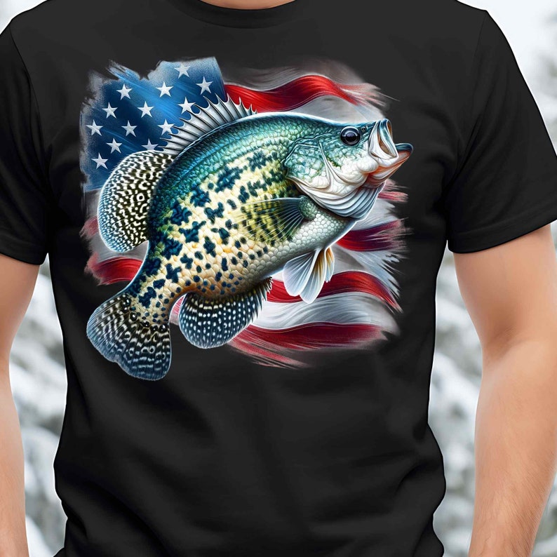 Op de afbeelding: Een zwart T-shirt met een afbeelding van een crappie-vis die voor een Amerikaanse vlag zwemt.