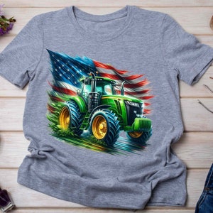 K&ouml;nnte beinhalten: Ein graues T-Shirt mit einem gr&uuml;nen Traktor, der vor einer zerfetzten amerikanischen Flagge f&auml;hrt.
