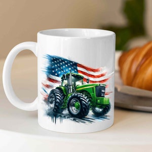 K&ouml;nnte beinhalten: Eine wei&szlig;e Keramiktasse mit einem gr&uuml;nen Traktor und einem amerikanischen Flaggen-Design. Der Traktor f&auml;hrt durch ein Grasfeld und die Flagge weht im Wind.