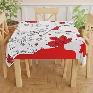 May include: White tablecloth with a red and black Canadian themed design. The design includes maple leaves, moose, hearts, and the word "Canada".
