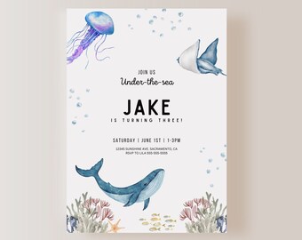 Puede incluir: Invitación a una fiesta de cumpleaños con temática submarina con una ballena azul, una medusa y una raya. La invitación dice "Únete a nosotros Bajo el mar Jake está cumpliendo tres años! Sábado 1 de junio 1-3pm 12345 Sunshine Ave. Sacramento, CA RSVP a Lila 555-555-5555"