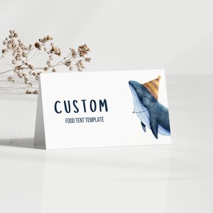 May include: A white food tent template with the text "CUSTOM FOOD TENT TEMPLATE" in navy blue. A watercolour illustration of a blue whale wearing a yellow and orange party hat is on the right side of the template.