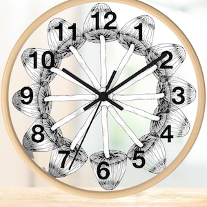 May include: A round, wooden-framed clock with a white face and black mushroom illustrations around the edge. The clock face has black numbers 1 through 12 and black hands.