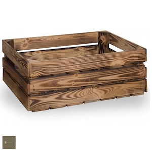 Può includere: Una cassa di legno rettangolare dall'aspetto rustico e invecchiato. La cassa è costruita con doghe orizzontali e presenta una finitura marrone scuro, che mette in risalto le venature naturali del legno. Ha i lati aperti e un'apertura per la maniglia.