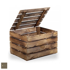 Può includere: Una cassa di legno per la conservazione con un coperchio incernierato. La cassa è realizzata in legno naturale con una finitura rustica. Il coperchio è aperto, rivelando l'interno vuoto della cassa.