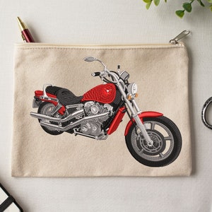 May include: A red and silver motorcycle embroidered on a beige canvas zippered pouch.