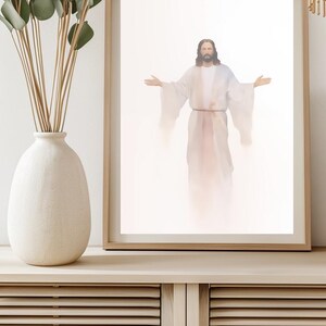 May include: A framed print of a painting depicting a man in a white robe with his arms outstretched. The background is a soft white with a light pink glow.