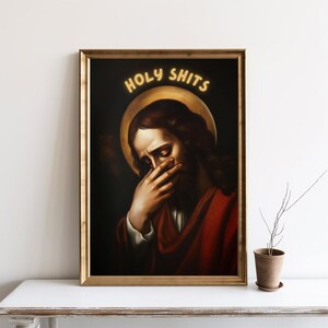 May include: A painting of Jesus with a halo above his head. He is covering his face with his hand and looking down. The text "HOLY SHITS" is written in yellow above his head.