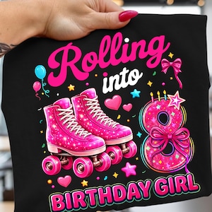 Può includere: T-shirt nero con un design di pattini a rotelle rosa, la scritta "Rolling into Birthday Girl" e il numero 8. Il design include cuori, stelle e palloncini. I pattini a rotelle sono rosa con lacci bianchi.