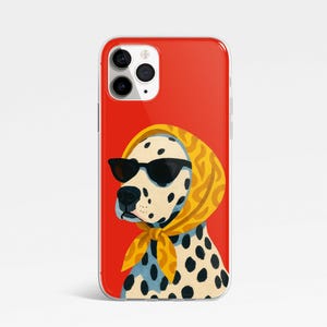 May include: A red iPhone case featuring a Dalmatian dog wearing black sunglasses and a yellow headscarf. The dog has black spots and is set against a solid red background.