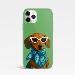 May include: A clear phone case featuring a dachshund wearing white sunglasses and a blue scarf with a leaf pattern. The dog is brown with dark brown ears and nose. The background is a solid green.