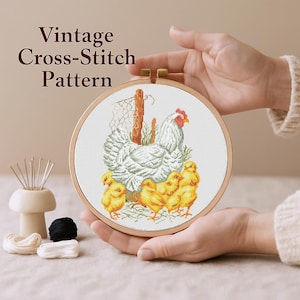 Może przedstawiać: Wzór do haftu krzyżykowego w stylu vintage przedstawiający kurę z kurczętami, umieszczony w drewnianej tamborku. Projekt zawiera białą kurę, żółte kurczaki i napis "Vintage Cross-Stitch Pattern".