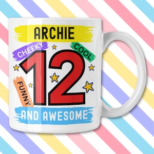 Può includere: Tazza in ceramica bianca con il nome "ARCHIE" in lettere nere sopra il numero rosso "12". La tazza presenta le parole "CHEEKY", "COOL", "FUNNY" e "AND AWESOME" in vari colori. Stelle gialle sparse.