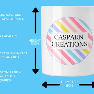 May include: White ceramic mug with a handle, featuring a colorful circular design with the text "CASPARN CREATIONS." The mug is 10cm tall with an 8cm diameter and has an 11oz capacity. It is microwave and dishwasher safe.