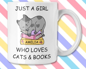 May include: White ceramic mug with a handle featuring a gray cat sleeping on a stack of books. The mug has the text "JUST A GIRL WHO LOVES CATS & BOOKS" and the name "AMELIA" on the bottom book.
