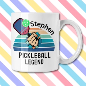 May include: White ceramic mug with a handle featuring a pickleball design. The design includes a pickleball paddle, ball, and the name "Stephen" above the words "PICKLEBALL LEGEND" in black text.