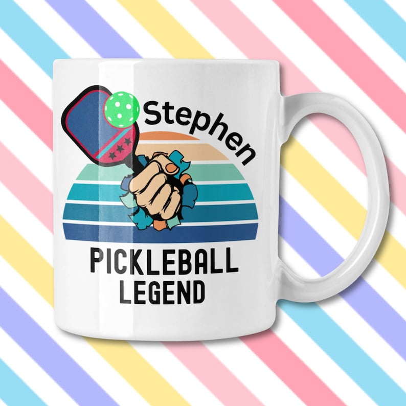May include: White ceramic mug with a handle featuring a pickleball design. The design includes a pickleball paddle, ball, and the name "Stephen" above the words "PICKLEBALL LEGEND" in black text.