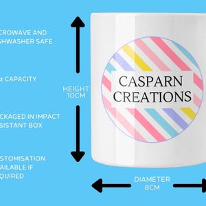May include: White ceramic mug with a colorful striped design and the text "CASPARN CREATIONS." The mug has an 11oz capacity, is 10cm tall, and 8cm in diameter. It is microwave and dishwasher safe.