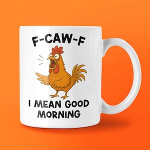 May include: White ceramic mug featuring a cartoon chicken illustration. The chicken is brown and orange with an open beak. The mug has the text "F-CAW-F" above the chicken and "I MEAN GOOD MORNING" below.