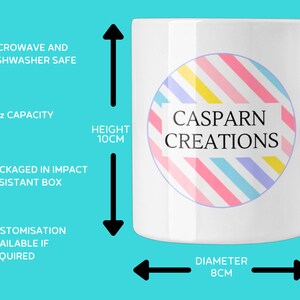 Może przedstawiać: Biały ceramiczny kubek z uchwytem, ​​z kolorowym okrągłym wzorem i napisem "CASPARN CREATIONS". Kubek ma pojemność 11 uncji, wysokość 10 cm i średnicę 8 cm. Można go używać w kuchence mikrofalowej i zmywarce.