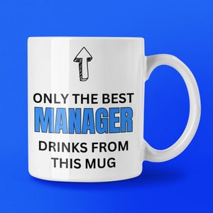 May include: White ceramic mug with a blue handle and the text "ONLY THE BEST MANAGER DRINKS FROM THIS MUG" in black and blue. An upward-pointing arrow is above the text. The mug is set against a blue background.