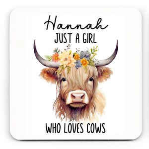 May include: Square coaster featuring a watercolor illustration of a Highland cow with a floral crown. The text reads "Hannah JUST A GIRL WHO LOVES COWS" in black script and block letters. The cow has long, shaggy, light brown fur and large horns.