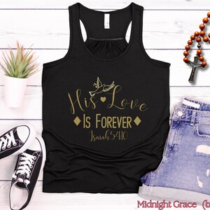 Könnte beinhalten: Schwarzes Tanktop mit einer goldenen Grafik, auf der "His Love Is Forever" mit einer Taube und einem Herzdesign steht. Der Text "Isaiah 54:10" ist ebenfalls auf der Grafik enthalten.