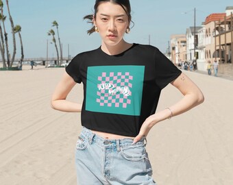 May include: A black cropped t-shirt with a pink and teal checkered pattern and the text "GOOD MORNING" in white.