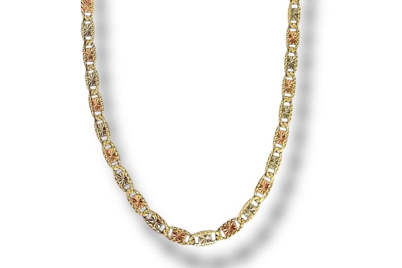 Op de afbeelding: Een goudkleurige ketting met een herhalend patroon van ovale schakels en stervormige accenten. De ketting heeft driekleurige elementen van geel, ros&eacute; en witgoud. De ketting wordt gepresenteerd tegen een witte achtergrond.